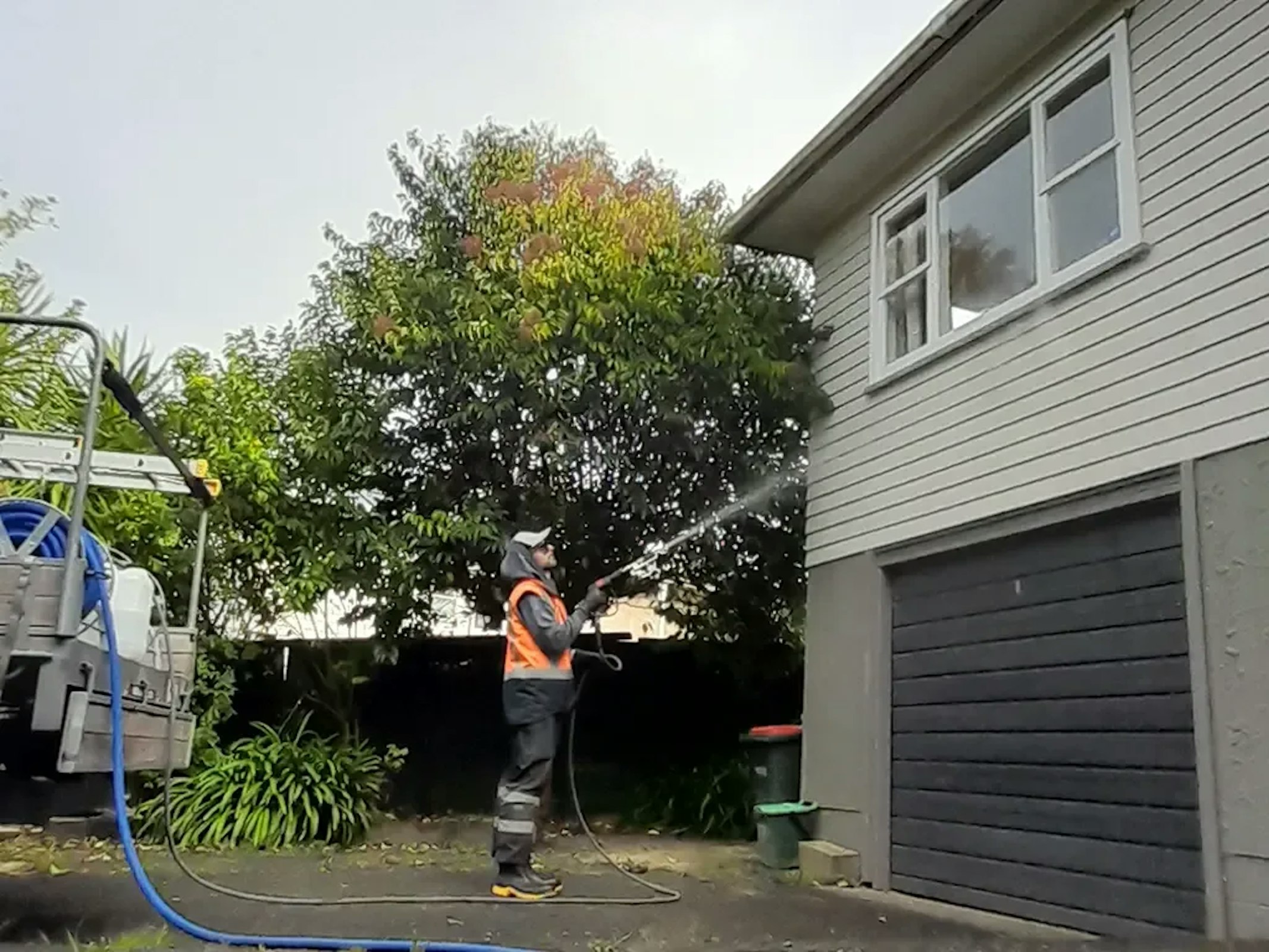 Blast off team member soft washing the outside of a residential property in Auckland